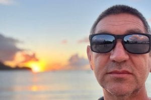 Ed Gregor with sun glasses and the sunset behind him